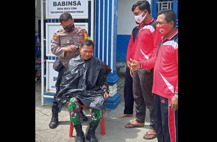 Kompak, Polisi Pangkas Rambut Tentara Depan Kantor Desa